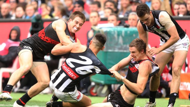 A melee breaks out on Saturday as Marley Williams of the Magpies is dragged down by Zach Merrett (L) and Joe Daniher of the Bombers.