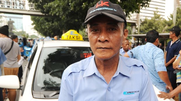 Tarwo, an Indonesian taxi driver, says the advent of Uber has left him having to borrow money from his employer to stay in business.