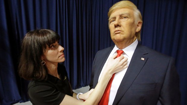 Ashley Priselac adjusts the tie on a life size wax figure of Donald Trump at Madame Tussauds in Orlando, Florida. 