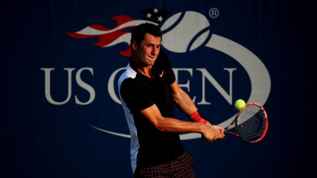 Safely through: Bernard Tomic returns a shot to Damir Dzumhur on day two of the US Open.