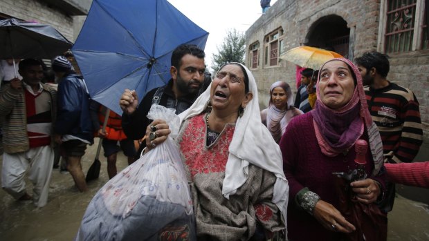 Flooding kills hundreds: A Kashmiri woman cries as she is evacuated to a safer area outside her home in Srinagar.