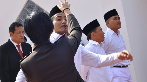 Mahendra, son of Bali Bomber Amrozi, centre, before raising the Indonesian flag on Independence Day 2017. 