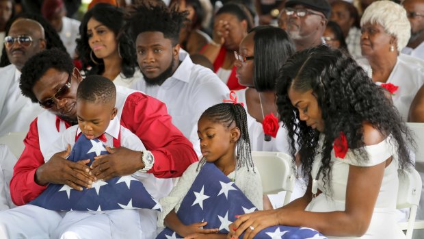 From left, Richard Johnson snr holding La David Johnson jnr, Ah'Leesya Johnson, and Myeshia Johnson attend the funeral.