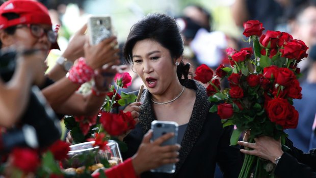 Thailand's former Prime Minister Yingluck Shinawatra receives roses from supporters as she arrives at the Supreme Court to make her final statements in a trial on a charge of criminal negligence in Bangkok on Tuesday.