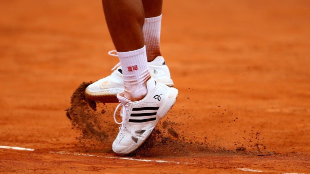 Court clay breaks up under Novak Djokovic.