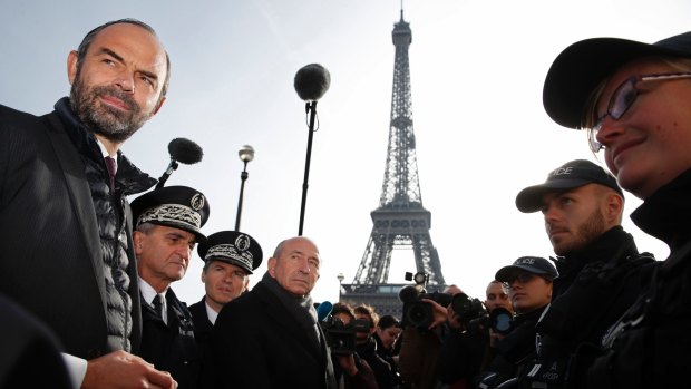 French Prime Minister Edouard Philippe, left, and Interior Minister Gerard Collomb, centre, meet police forces during a visit at the Eiffel Tower Tower.
