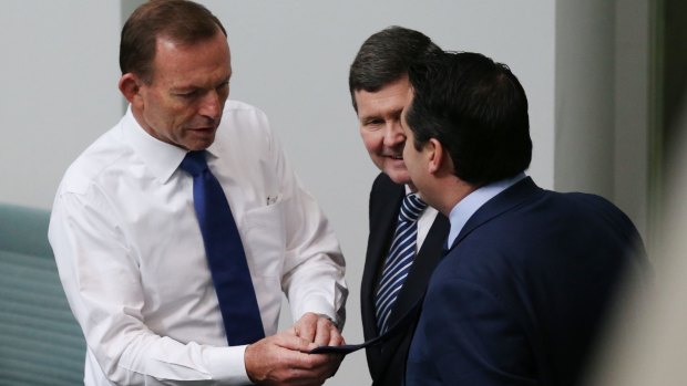 The ties that bind: Tony Abbott (left) examines the label on the tie of fellow conservative MP Michael Sukkar as Kevin Andrews looks on.