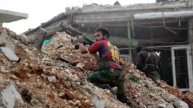 Syrian army soldiers fire their weapons during a battle with insurgents at the Ramouseh front line, east of Aleppo, Syria, last week.