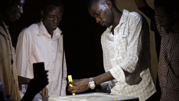 Election officials count votes by flashlight in a school used as a polling station in Niamey on Sunday.