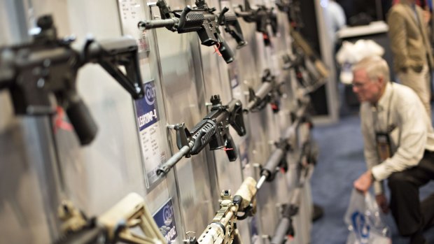 Rifles hang on display in the Colt's Manufacturing Co. booth at the 144th National Rifle Association Annual Meetings and Exhibits  in Nashville, Tennessee, in April.
