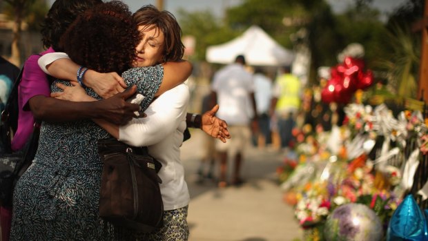 Mourners Maria Bornhorst, Patricia Bailey and Carol Reid embrace outside the Emanuel African Methodist Church.