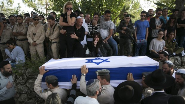 Grief: People gather for the funeral of Almog Shiloni, 20, who was stabbed by a Palestinian in Tel Aviv on Monday.