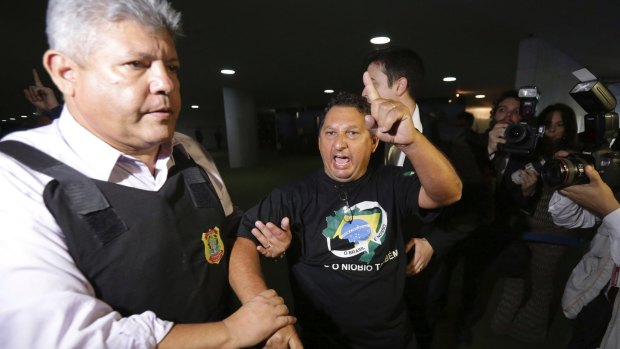 A man shouts slogans as he is escorted out of the Brazilian Congress on Wednesday.