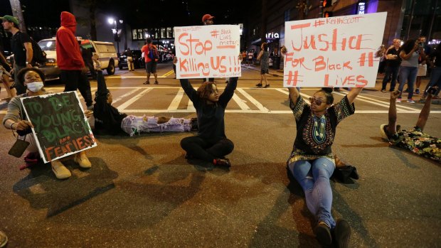 Demonstrators sit on a street during a protest in Charlotte. 
