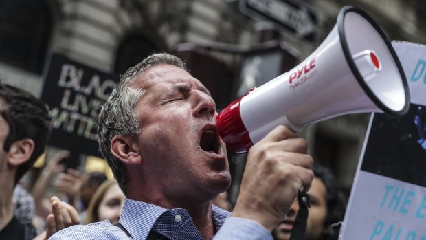 A demonstrator shouts into a megaphone during a rally outside of Trump Tower in New York.