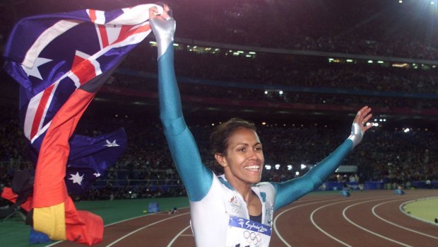Cathy Freeman carries both the Aboriginal and the Australian flags during a victory lap after winning the women's 400m final at the Sydney Olympics in 2000.