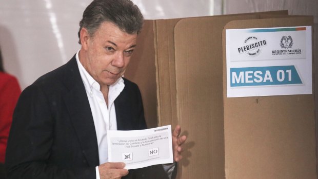 Colombian President Juan Manuel Santos votes 'yes' in the referendum on a peace accord to end the 52-year-old guerrilla war between the FARC and the state .