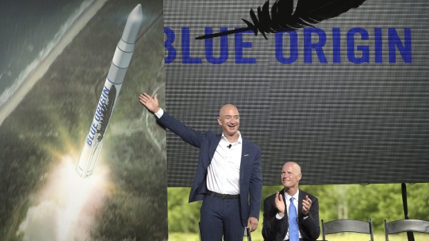 Amazon founder Jeff Bezos (left) unveils the new Blue Origin rocket, as Florida Governor Rick Scott applauds.