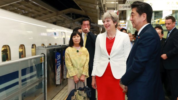 British Prime Minister Theresa May and Japanese Prime Minister Shinzo Abe, right, wait for their bullet train bound for Tokyo at Kyoto on Wednesday.