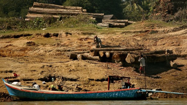 Men working with logs on the banks of the Irrawaddy River between Bhamo and Shwegu in Kachin state, Myanmar.
