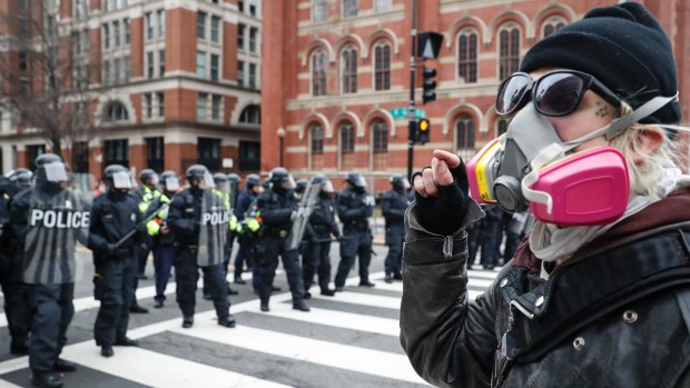 A protester faces off with a line of riot police in Washington, DC, during the inauguration.