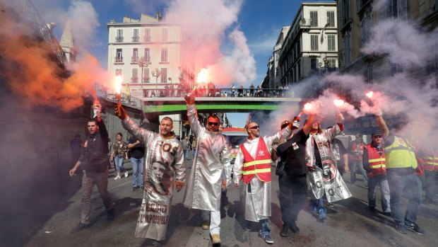 Steelworkers in Fos-sur-Mer burn flares during a national day of protest against proposed labour reforms in Marseille, France, on Tuesday.