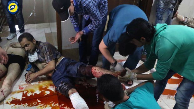 Victims are treated on the floor of a crowded clinic in Aleppo on Sunday.