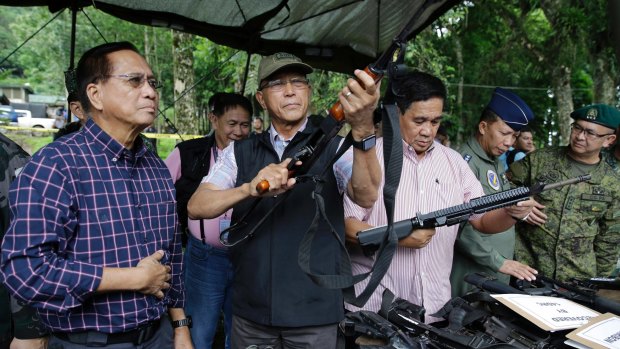Philippine Defence Secretary Delfin Lorenzana, centre, Philippine Presidential Adviser on the Peace Process Jesus Dureza, left, and National Security Adviser General Hermogenes Esperon, right, checks out firearms seized from Muslim militants in Marawi.