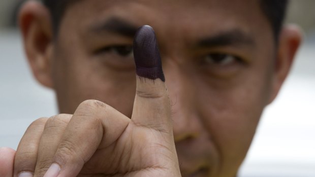 A man shows his finger marked with ink indicating he had voted in November's historic Myanmar election. 