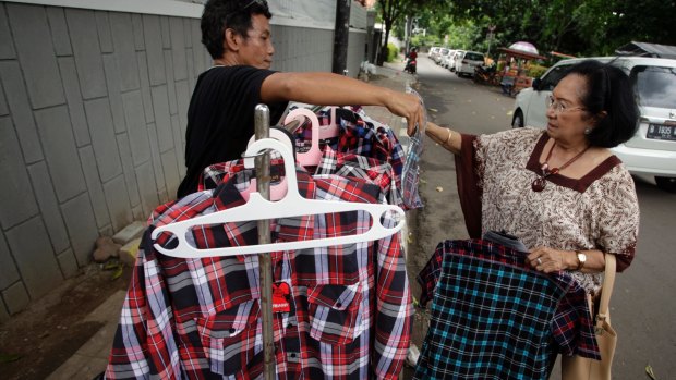A buyer chooses an 'Ahok shirt' in Jakarta.