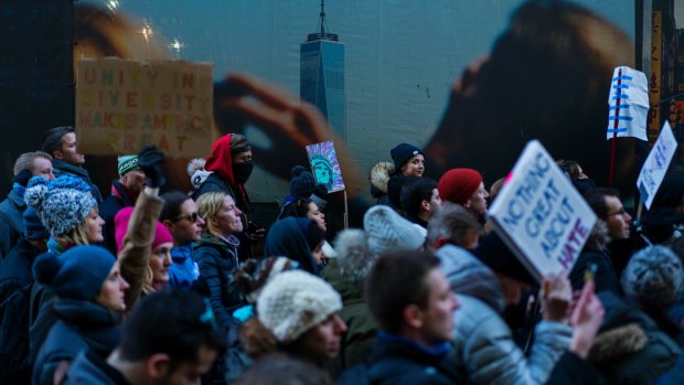With an image of One World Trade Center in the background, people march in New York, against the new president's executive order.