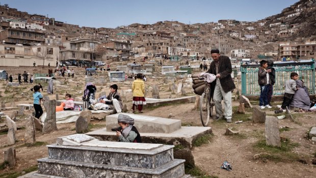 An Afghan boy plays with a toy gun at Kart-e-Sakhi cemetery in Kabul.