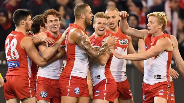 Big win: Swans players congratulate Buddy Franklin after he kicked a goal.