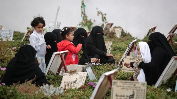 Yemeni women offer prayers at the grave of relatives killed during Yemen's ongoing conflict, during "martyr week" marked by Shiite rebels known as Houthis, at a cemetery in Sanaa, Yemen.