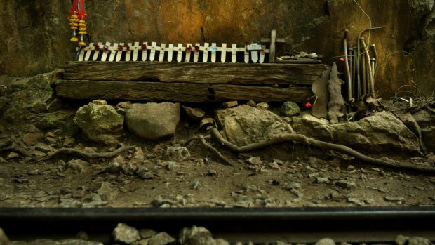 Remberance crosses bearing poppies sit among the original railway sleepers, rail pegs and track at the site of the infamous World War II Burma Railroad.