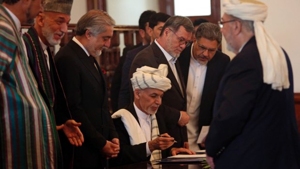 Afghan President Ashraf Ghani, centre, with Afghan chief executive Abdullah Abdullah third from left and former president Hamid Karzai second from left, signs the peace agreement with Gulbuddin Hekmatyar in September 2016.