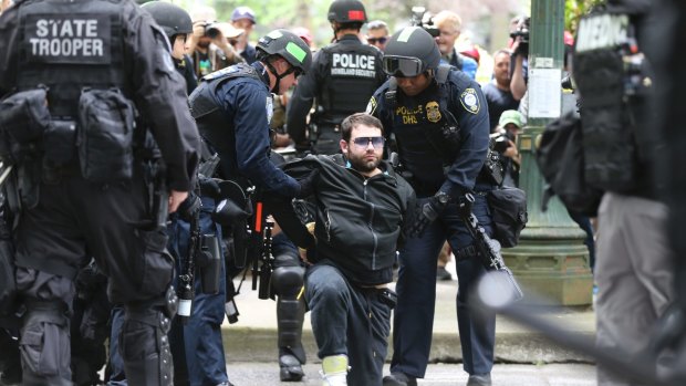 A protester is detained by police during Sunday's demonstration in Portland, one of 14 arrests on the day.