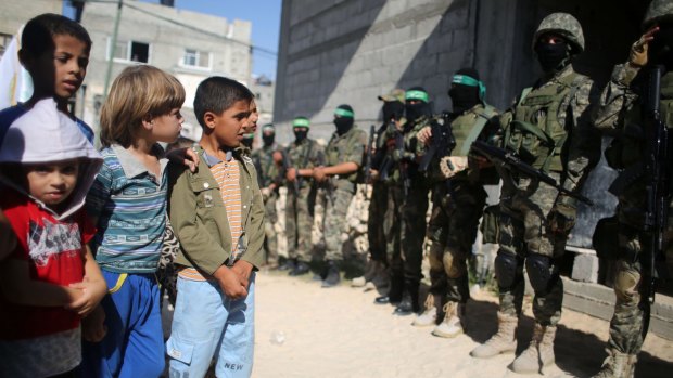 Children in Raffah, Gaza, gaze at members of the Ezzedine al-Qassam Brigades, Hamas' armed wing, in August last year.