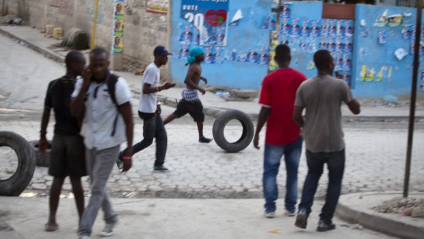 Supporters of presidential candidate Moise Jean-Charles gather tyres to be burnt in protests against poll results. 