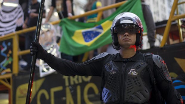 A demonstrator wears a helmet and a sign on his chest that reads "Out Dilma" during an anti-government protest in Rio de Janeiro, Brazil, on September 3.
