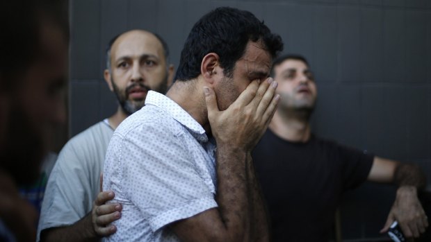 A Palestinian grieves the death of his relatives in a van hit by air strikes on Gaza City in the hours before the ceasefire. An estimated 1442 Palestinians have been killed since July 8.