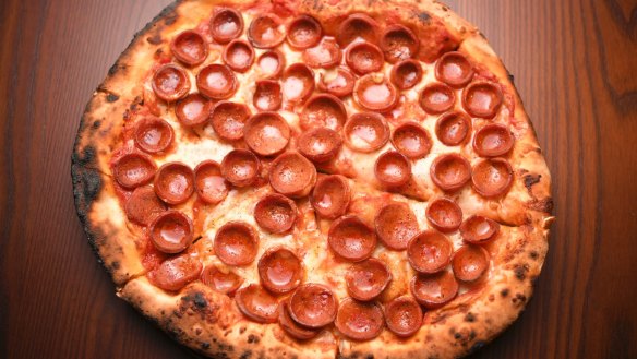 Pepperoni pizza is assembled with precision.