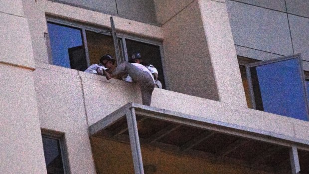 A man who spent the day on an awning on a high rise building in Chatswood gives himself up to Police Rescue members. 