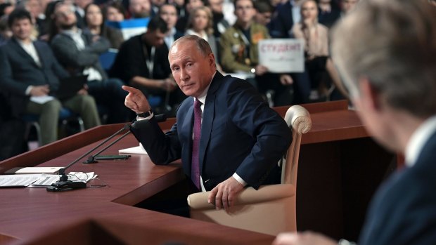 Russian President Vladimir Putin points to reporters during his annual news conference in Moscow.