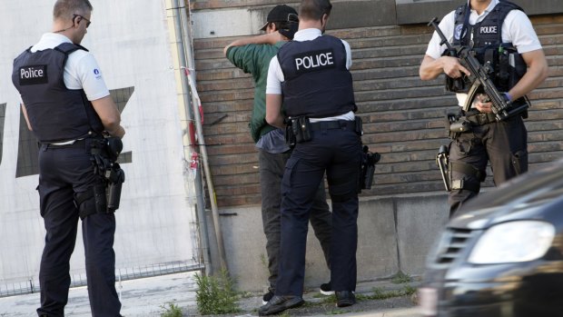 Police officers check the identification of a man near the police headquarters in Charleroi after the machete attack on August 6.