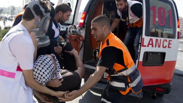 Palestinians help an injured demonstrator during clashes with Israeli troops near Ramallah, West Bank, on Friday.