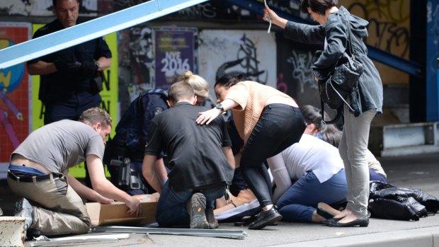Witnesses help the injured on Bourke Street.