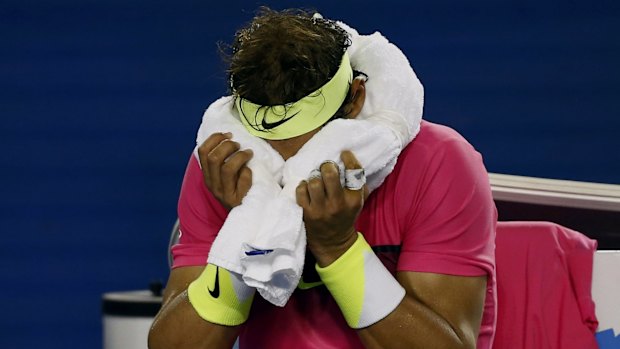 Feeling the effects: Rafael Nadal applies an ice-pack to his head.