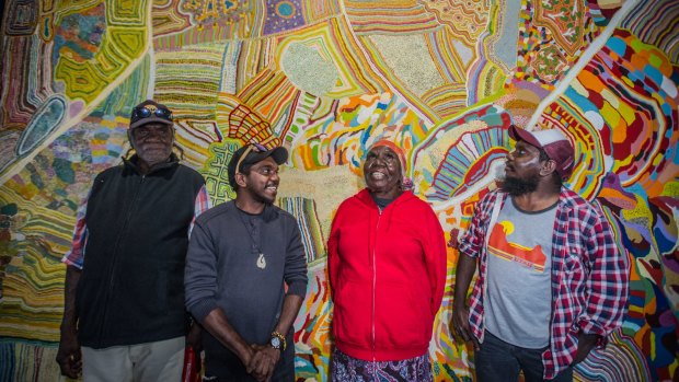 Muuki, Ignatius, Nola and Curtis Taylor stand in front of the painting Yarrakalpa. 