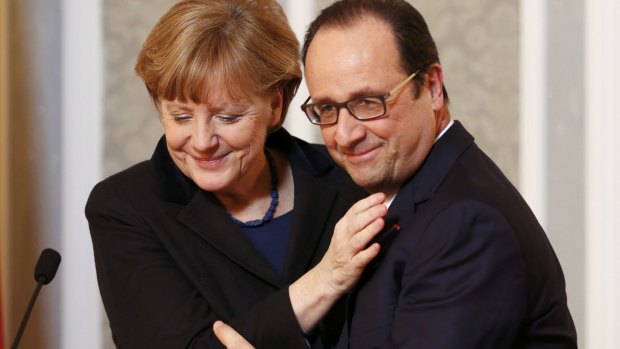 Germany's Chancellor Angela Merkel embraces France's President Francois Hollande during a meeting with the media after peace talks.